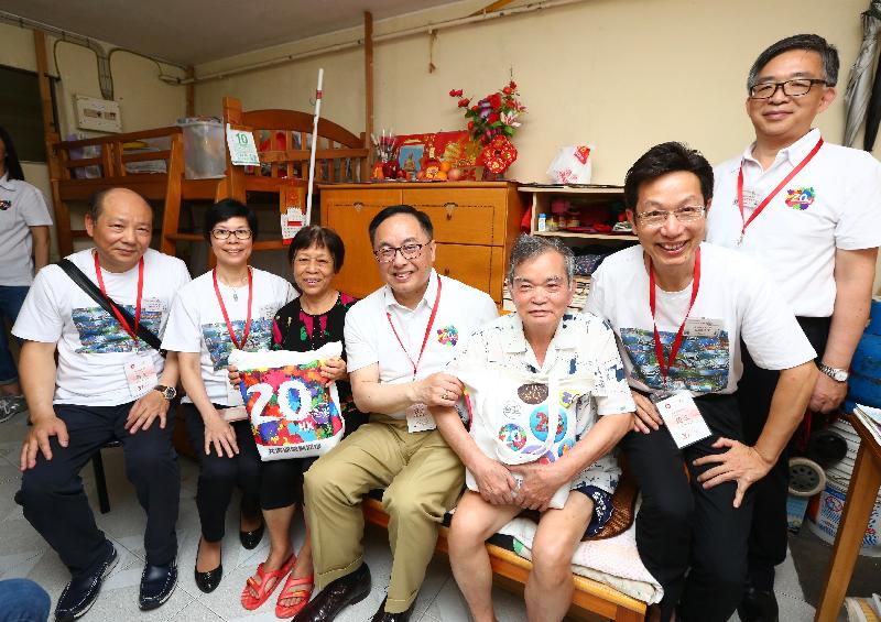 The Secretary for Innovation and Technology, Mr Nicholas W Yang (centre); the District Officer (Southern), Mr Chow Chor-tim (fist right); and the Chairman of the Southern District Council, Mr Chu Ching-hong (second right) join a group photo with an elderly couple during home visits in Ap Lei Chau Estate under the 'Celebrations for All' project this afternoon (June 10).