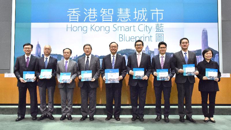 The Secretary for Innovation and Technology, Mr Nicholas W Yang (centre), is joined by the Permanent Secretary for Innovation and Technology, Mr Cheuk Wing-hing (fourth left); the Under Secretary for the Environment, Mr Tse Chin-wan (second left); the Under Secretary for Development, Mr Liu Chun-san (first left); the Under Secretary for Education, Dr Choi Yuk-lin (first right); the Under Secretary for Commerce and Economic Development, Dr Bernard Chan (second right); the Under Secretary for Financial Services and the Treasury, Mr Joseph Chan (third right); the Under Secretary for Transport and Housing, Dr Raymond So (third left); and the Government Chief Information Officer, Mr Allen Yeung (fourth right), at a press conference today (December 15) on the Smart City Blueprint for Hong Kong, showing the Government's determination and collaboration to promote smart city development.