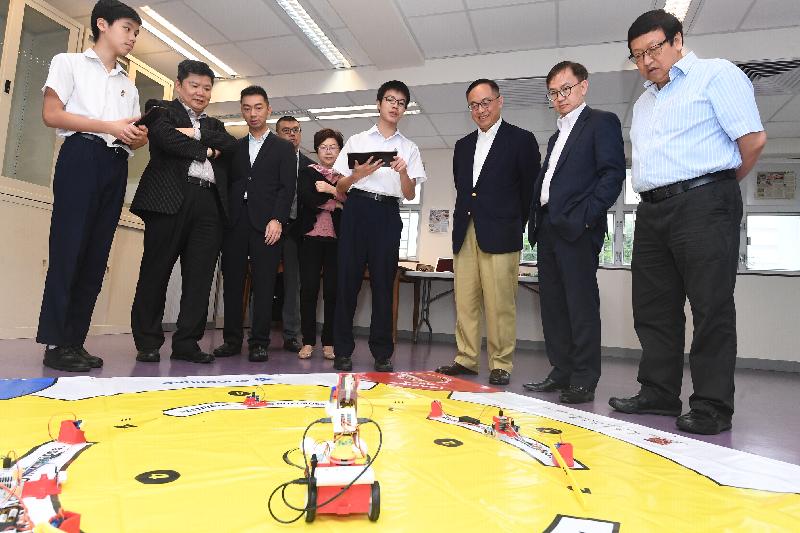 The Secretary for Innovation and Technology, Mr Nicholas W Yang (third right), receives a brief introduction from students of SKH Tang Shiu Kin Secondary School on their STEM (science, technology, engineering and mathematics) activities during his visit to Wan Chai District today (May 27). Also present are the Under Secretary for Innovation and Technology, Dr David Chung (second right); the Chairman of the Wan Chai District Council, Mr Stephen Ng (first right); and the District Officer (Wan Chai), Mr Rick Chan (fourth left).