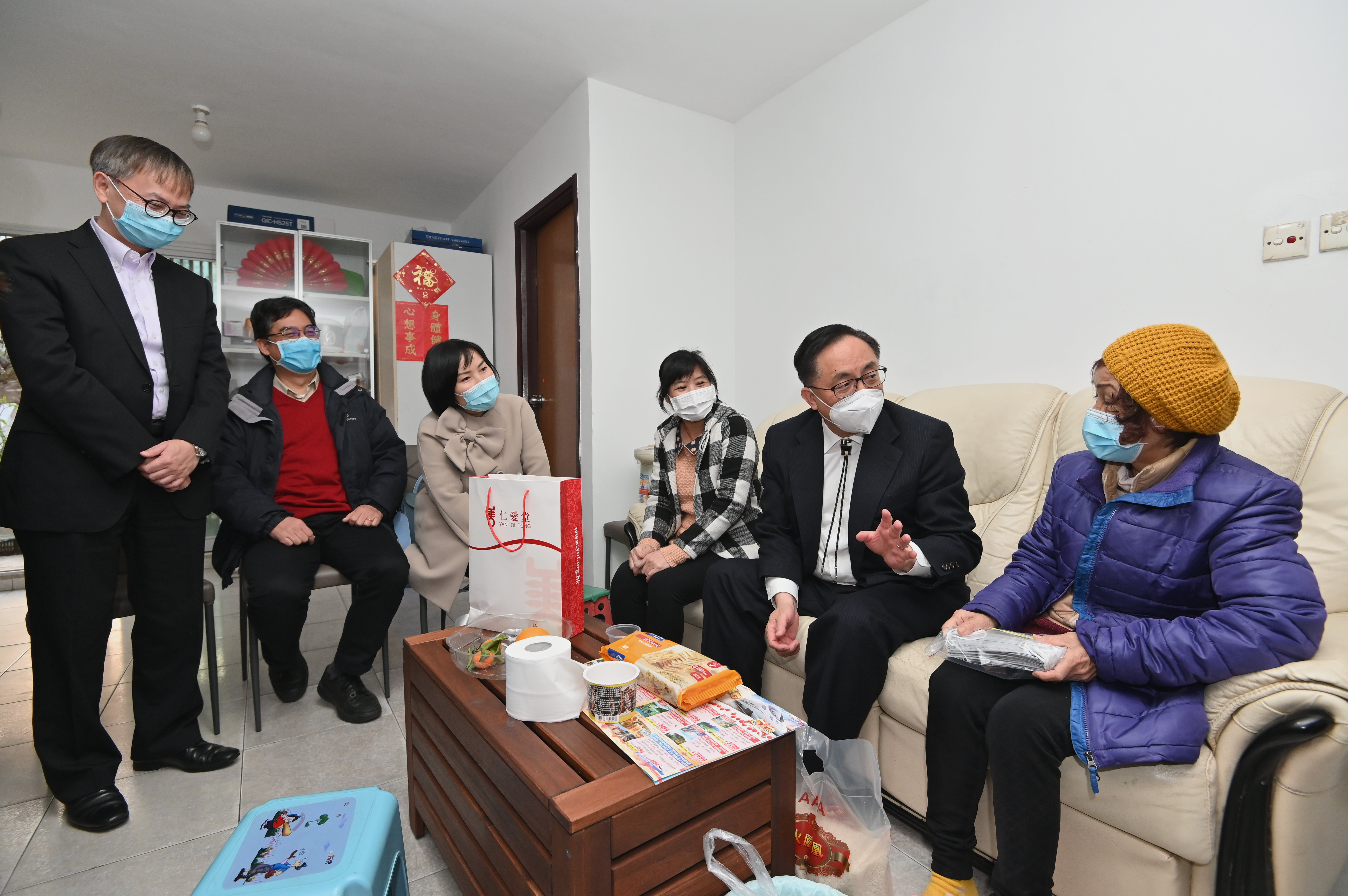 The Secretary for Innovation and Technology, Mr Nicholas W Yang (second right), together with the Under Secretary for Innovation and Technology, Dr David Chung (first left); the Political Assistant to the Secretary for Innovation and Technology, Miss Lillian Cheong; and representatives of Yan Oi Tong visited several households living in social housing under the Community Housing Movement in Tuen Mun this evening (February 18). Surgical masks donated by private organisations to the Government are distributed to the elderly and grassroots families in need during the visit.