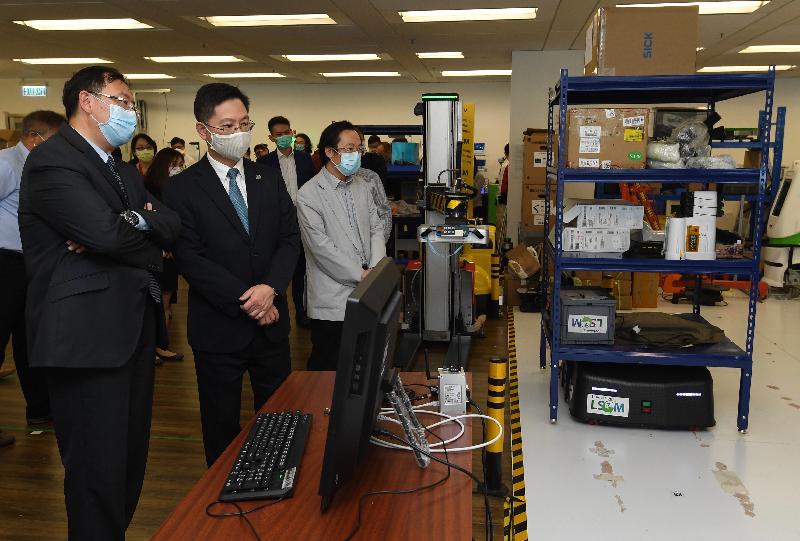 The Secretary for Innovation and Technology, Mr Alfred Sit (centre), today (May 7) receives a briefing by the Chief Executive Officer of the Logistics and Supply Chain MultiTech R&D Centre, Mr Simon Wong (left), on electronic wristbands for home quarantines and its backend system.