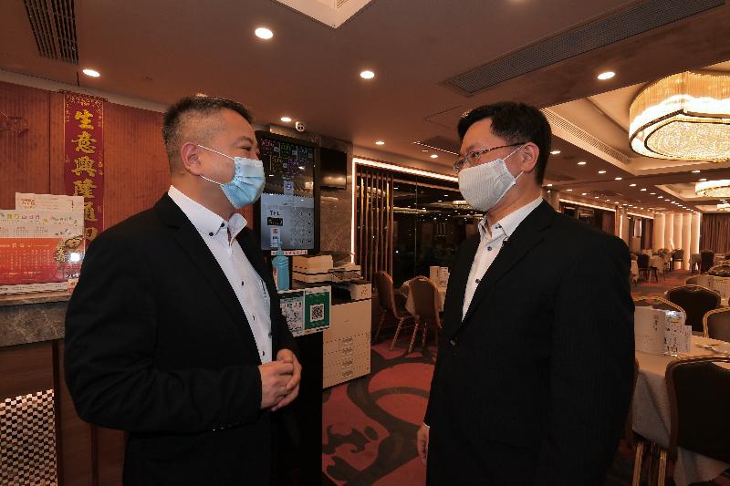 The Secretary for Innovation and Technology, Mr Alfred Sit (right), visited a Chinese restaurant in Kowloon City today  (November 18) to learn more about the implementation of the "LeaveHomeSafe" mobile app.