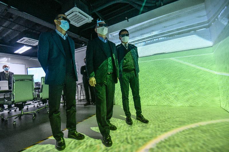 The Secretary for Innovation and Technology, Mr Alfred Sit (centre), today (December 17) learns about the layout of the Kai Tak Sports Park through the Building Information Modeling Cave Automatic Virtual Environment (BIM CAVE) technology at the Kai Tak Sports Park construction site. Looking on are the Executive Director of the Construction Industry Council, Mr Albert Cheng (right), and the Managing Director of Hip Hing Construction, Mr Chu Tat-chi (left).