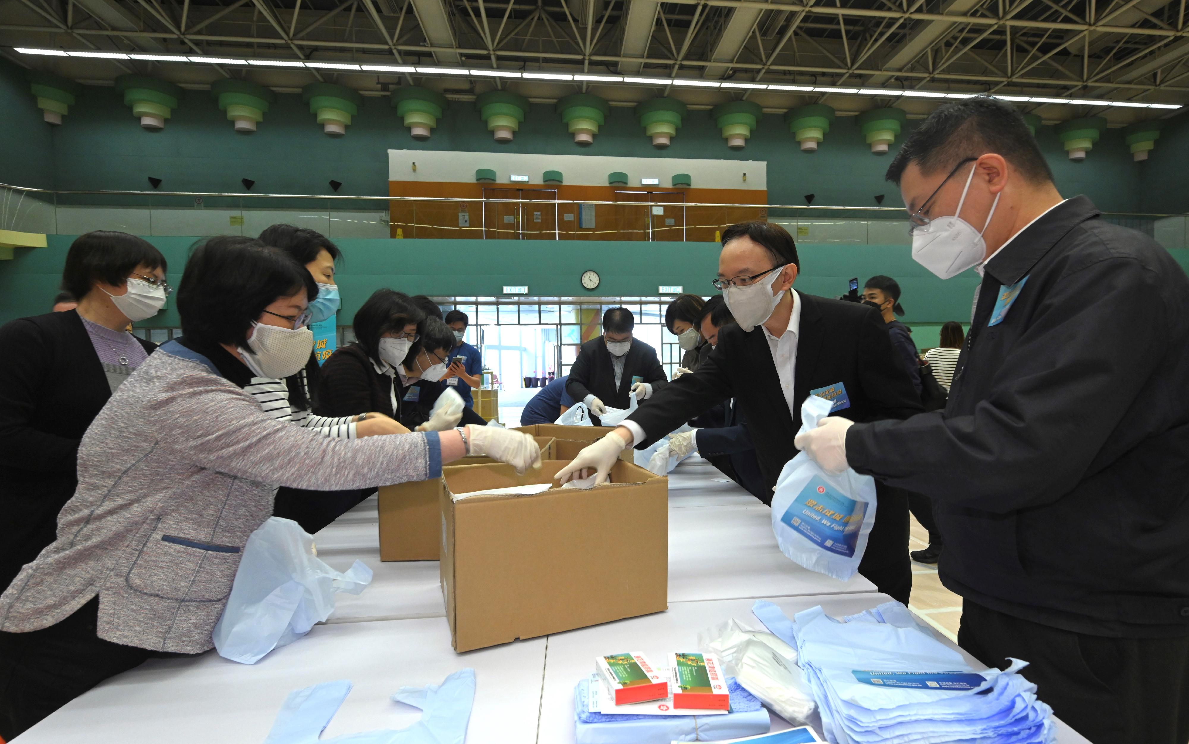 創新及科技局（創科局）局長薛永恒（右一）今日（三月三十一日）聯同創新及科技局常任秘書長蔡淑嫻（左一）、政府資訊科技總監林偉喬（右二）、創新科技署署長潘婷婷（左四）和效率專員李國彬（左五）到香港公園體育館的「防疫服務包」包裝中心，為創科局和旗下部門的同事打氣，同時身體力行參與「防疫服務包」的包裝工作。