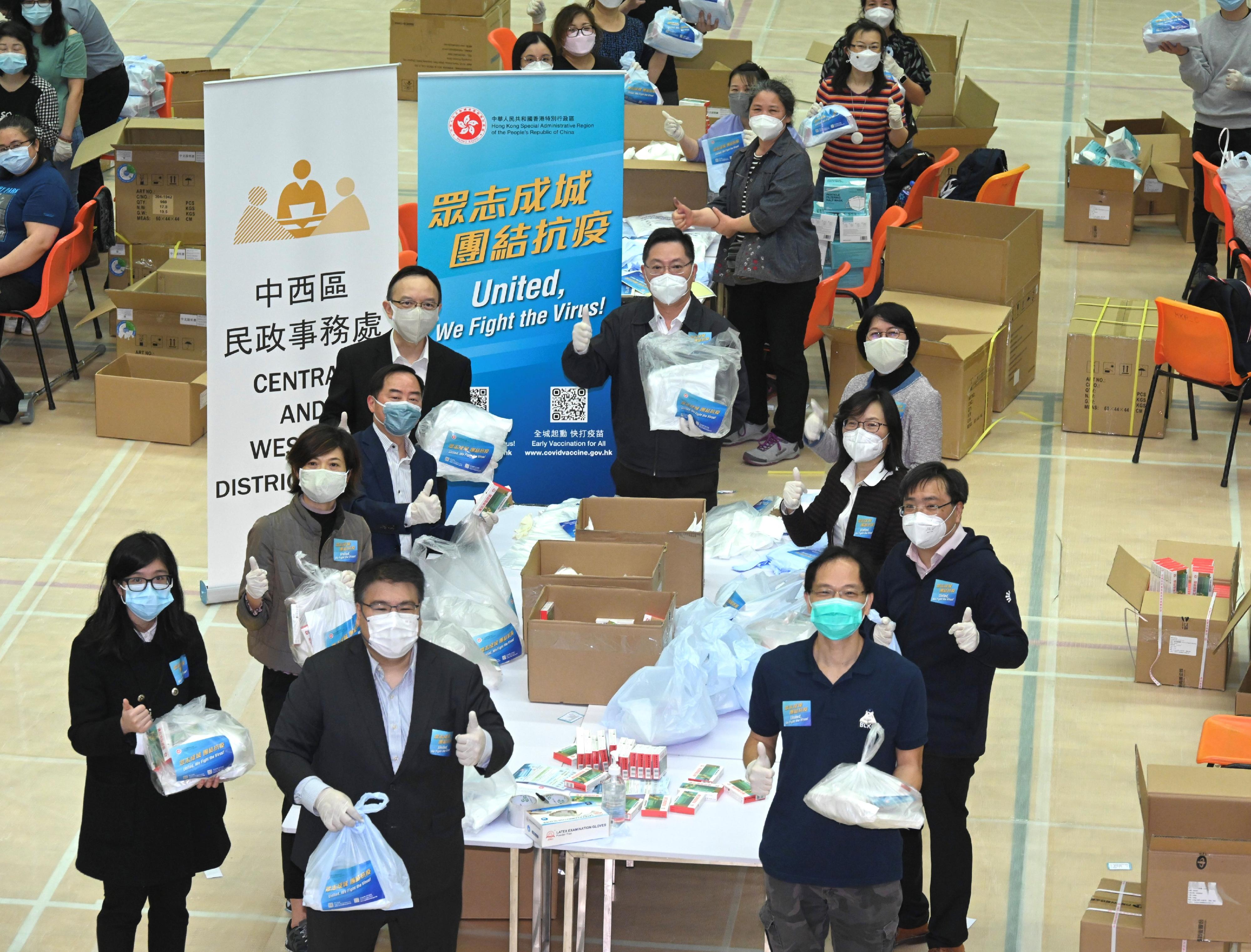 創新及科技局（創科局）局長薛永恒（中）今日（三月三十一日）到香港公園體育館的「防疫服務包」包裝中心，集合創科局和旗下部門同事力量，投入包裝工作，眾志成城，團結抗疫。旁為創新及科技局常任秘書長蔡淑嫻（右四）、政府資訊科技總監林偉喬（左四）、創新科技署署長潘婷婷（右三）和效率專員李國彬（右二）。