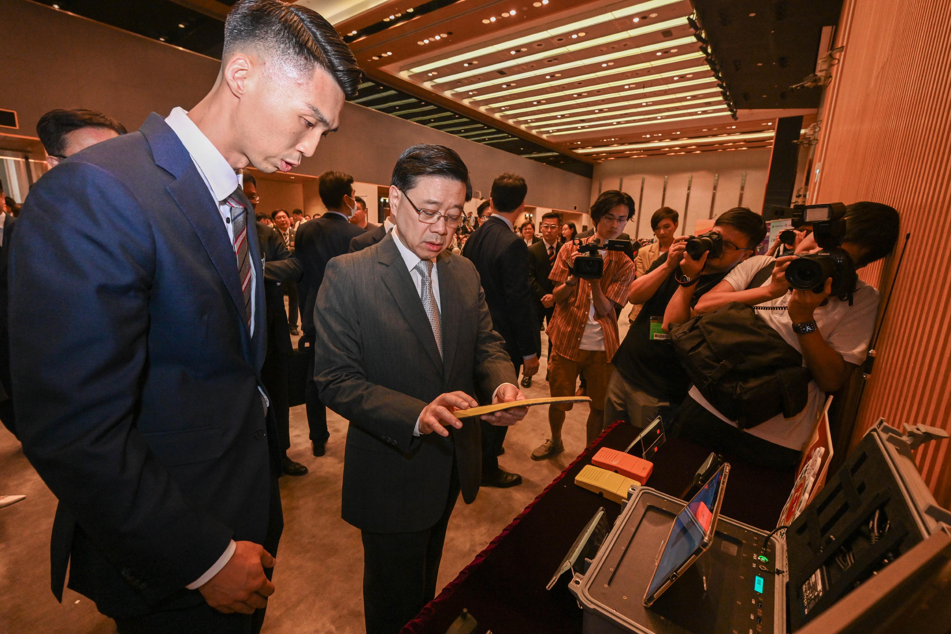 The Chief Executive, Mr John Lee, attended the Reception for I&T Awards 2024 today (July 15). Photo shows Mr Lee (second left) touring the winning projects showcase. 
